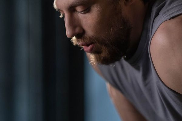 Close-up of a man's focused face during a difficult exercise.